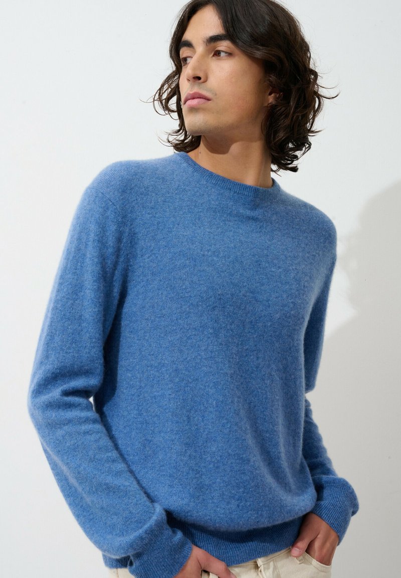 Hellblaue Strickpullover aus weichem, strukturiertem Material. Mit Rundhalsausschnitt und langen Ärmeln mit gerippten Bündchen und Saum.