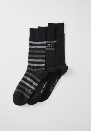 Ensemble de trois paires de chaussettes en noir et gris. Une paire présente des rayures horizontales, toutes ont des accents de logo et des poignets côtelés. Tissu en mélange de coton.