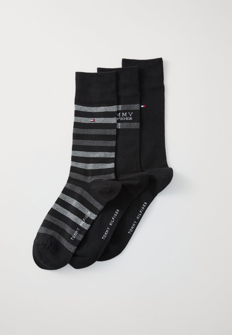 Ensemble de trois paires de chaussettes en noir et gris. Une paire présente des rayures horizontales, toutes ont des accents de logo et des poignets côtelés. Tissu en mélange de coton.