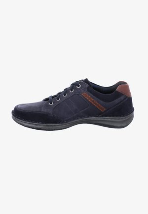 Zapatilla de ante azul marino con acentos grises, detalles cosidos, punta redonda y suela de goma negra. Presenta un diseño de cordones y cuello acolchado.