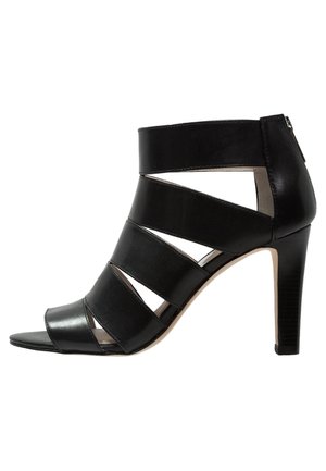 Sandale noire à talon haut avec larges brides horizontales, bout ouvert, côtés découpés et fermeture éclair au dos.