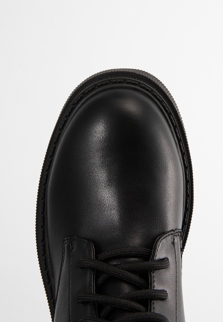 Stivale in pelle nera con punta tonda e lacci neri, mostrato in vista dall'alto su uno sfondo bianco semplice.