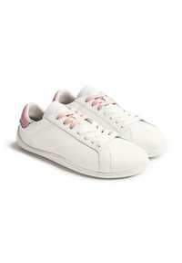 Zapatillas de cuero blancas con cordones rosas, un acento en el talón rosa en contraste y una textura suave. Punta redondeada y suela de goma plana.