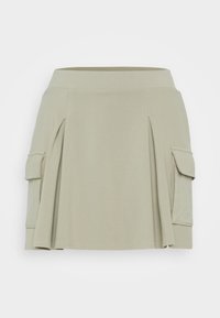 Světlá zelená sukně z měkké tkaniny, s jednoduchým designem a sklady, s bočními cargo kapsami pro zvýšenou praktičnost.