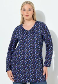 Pitkähihaisen tunikan tummansininen väri toistaa värikkäitä jälkiruokia ja välineitä, ja siinä on V-pääntie sekä rento istuvuus.