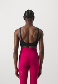 Stronger SHAPING CUT OUT BRA - Sujetadores deportivos con sujeción media - black