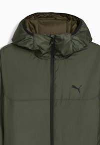 Jachetă ușoară de culoare verde măslinie, cu fermoar pe față, glugă și accente negre. Prezintă un logo Puma pe piept și o textură netedă, lucioasă.