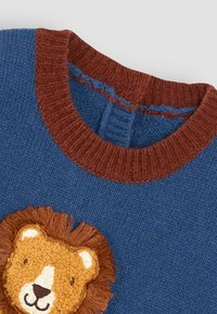 Blauer gestrickter Pullover mit braunem geripptem Kragen und einem strukturierten Löwenpatch auf der Vorderseite, mit weichen Fasern und gestickten Details.