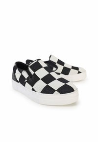Le scarpe slip-on in bianco e nero presentano un motivo a scacchi, materiale in tela, colletto imbottito e una suola in gomma bianca texture.