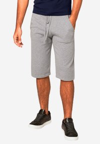 Pantaloni corti in cotone grigio con vita elasticizzata, regolazione a cordino e tasche laterali. Abbinali a sneaker scure per un look casual.