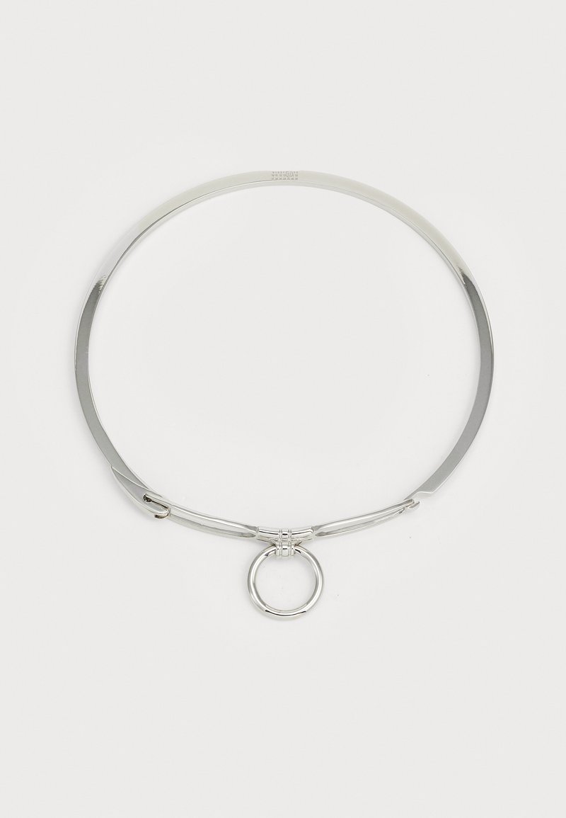 Colar choker de metal prateado com um acabamento liso e polido. Apresenta um anel circular central e um design minimalista e elegante.