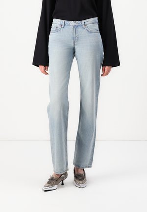Light blue denim jeans with a straight leg fit, five-pocket design, and mid-rise waist. Worn with metallic shoes and a black top.