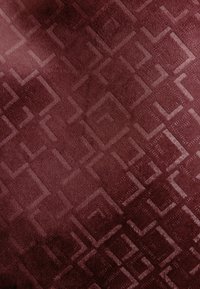 Tissu en velours avec un motif carré géométrique en relief dans des nuances variées de bordeaux profond et de marron.