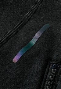 Tejido negro con una textura suave, que presenta una franja iridiscente en tonos de verde, azul y púrpura. Incluye una cremallera visible.