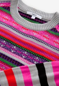 Pulover multicolor cu un guler ribber gri. Modelele includ dungi roz, violet și verzi cu desene geometrice. Eticheta brandului este vizibilă.