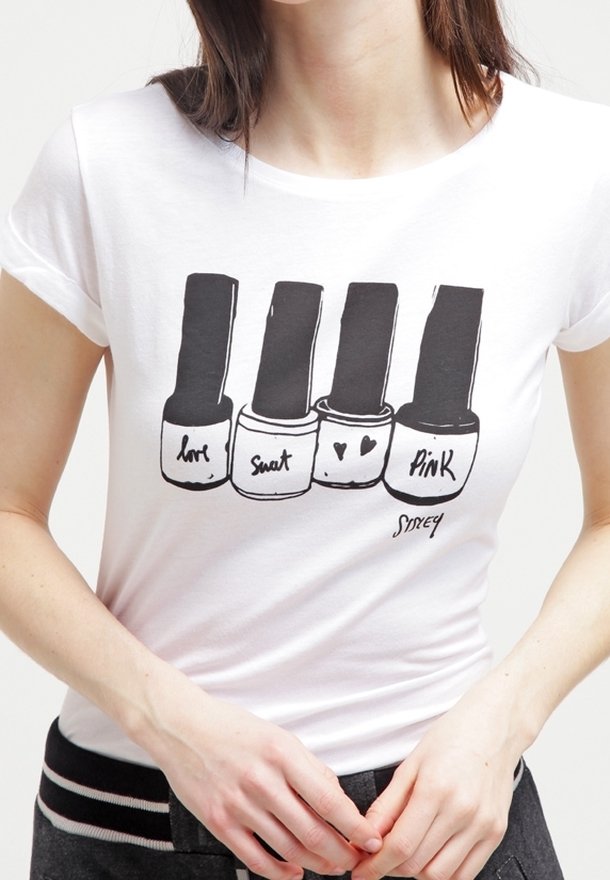Bílý bavlněný tričko s grafikou čtyř flakonů s lakem na nehty, s etiketami "láska," "pot," srdce a "růžová," na jednobarevném pozadí.