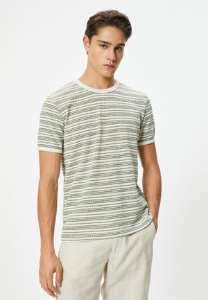 Camiseta de rayas en verde claro y blanco, hecha de un tejido suave, con mangas cortas y cuello redondo. Patrón geométrico sutil.