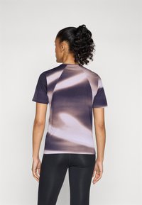 Danse trøye med korte ermer i lilla og beige gradient, med glatt stoff, tettsittende design og raglanermer.