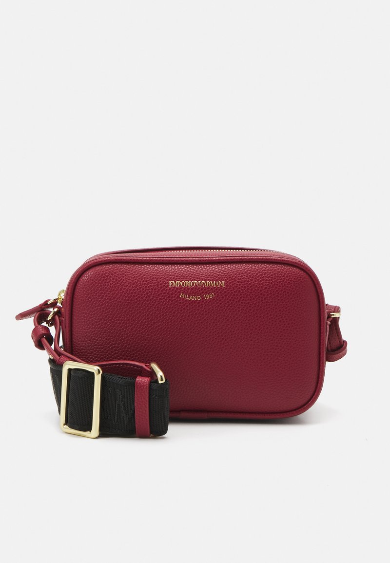 Borsa a tracolla rossa in pelle con finitura testurizzata, hardware dorato e una tracolla nera regolabile con motivo logo. Chiusura con zip nella parte superiore.