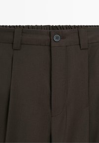 Dark brown pants with elastic waistband, button closure, belt loops, and front pleats.