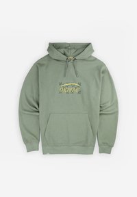 Hoodie vert en tissu doux, avec un logo central orné d'éléments décoratifs, une poche kangourou et des cordons de serrage ajustables sur la capuche.