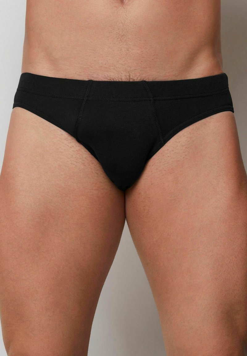Svarta bomullsboxershorts med en tajt passform, med platta sömmar och en låg midjeresår. Slät yta utan synliga mönster eller dekorationer.