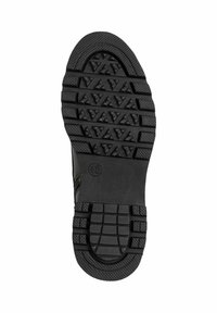 Semelle de chaussure en caoutchouc noir avec une surface texturée, présentant un motif de semelle composé de triangles en relief et de lignes courbes pour une meilleure adhérence et traction.