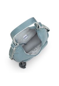 Light blue handbag with a soft fabric exterior, zip closure, and adjustable strap. Includes a plush pom-pom detail and interior pocket.