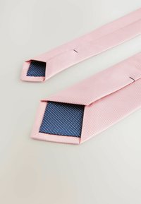 Rosa gemusterte Krawatte mit strukturierter Oberfläche, die eine einfarbige navyblaue Unterseite mit weißen Punkten und schrägen Spitzen aufweist.