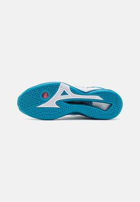 Semelle de chaussure en bleu et blanc, avec un motif texturé pour une meilleure adhérence, un logo visible et un design incurvé pour des performances accrues.