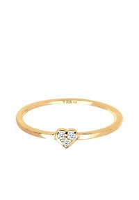 Bague en argent sterling plaqué or avec une fine bande et un design en forme de cœur, présentant trois petites gemmes transparentes au centre.