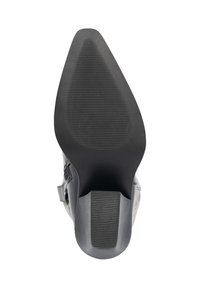 Suela de zapato de tacón alto negro con un patrón texturizado. Presenta una forma puntiaguda y un tacón sólido con ranuras diagonales para mayor tracción.