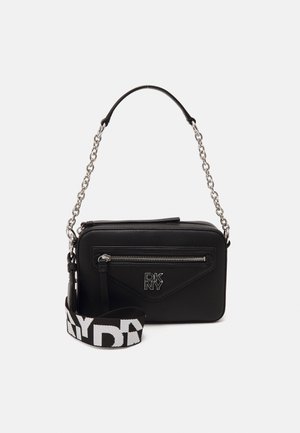 Sac bandoulière rectangulaire noir avec bandoulière chaîne argentée, poche avant zippée, logo DKNY et bandoulière en tissu noir et blanc amovible.