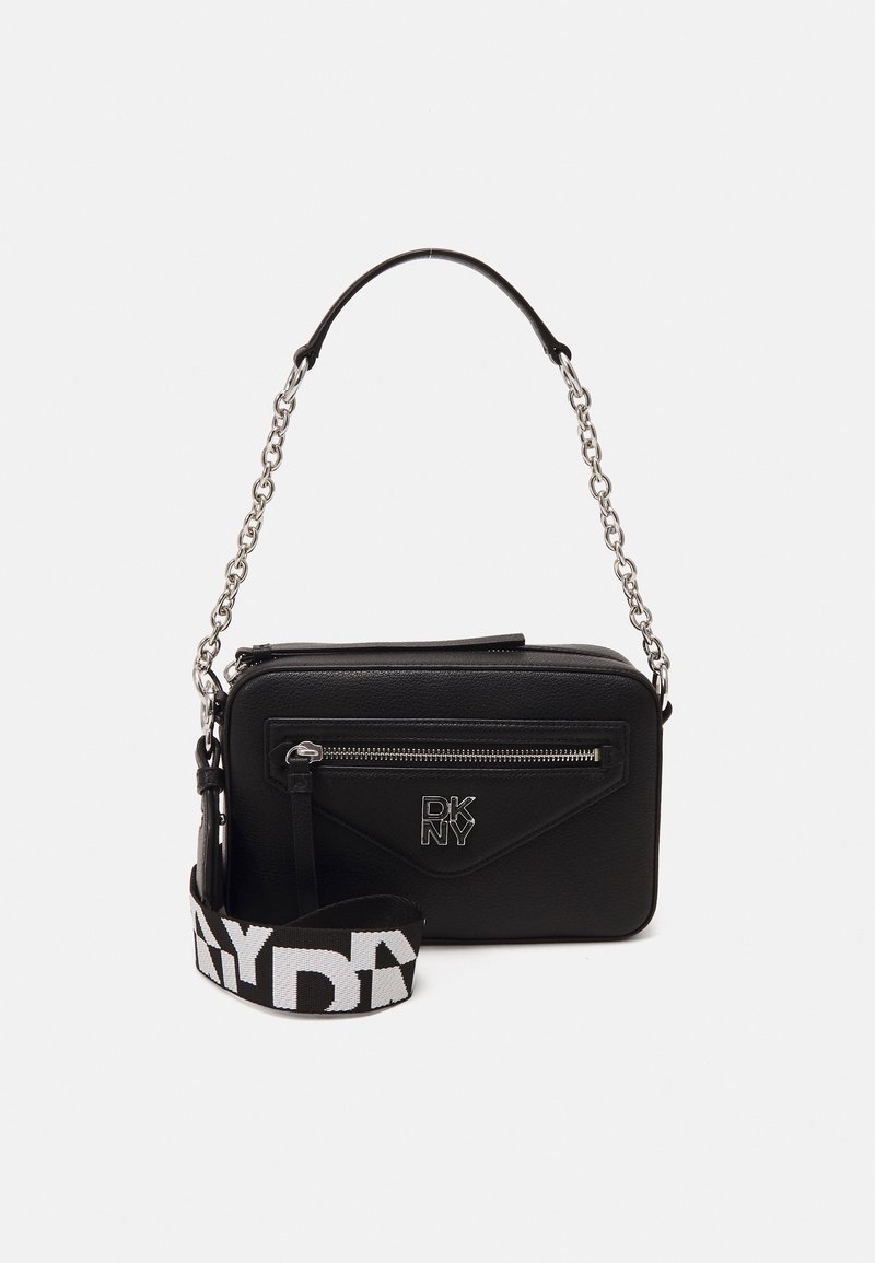 Sac bandoulière rectangulaire noir avec bandoulière chaîne argentée, poche avant zippée, logo DKNY et bandoulière en tissu noir et blanc amovible.