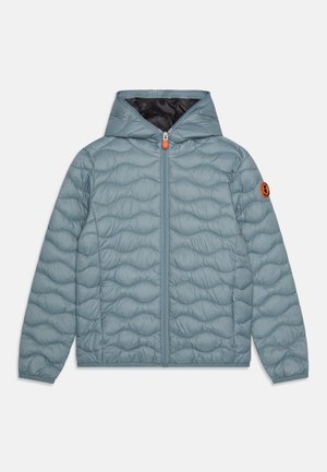 Hellblau gesteppte Jacke mit Kapuze, ausgestattet mit einem Frontreißverschluss und einem orangefarbenen Zipppull. Enthält ein Logo-Patch auf dem linken Ärmel.