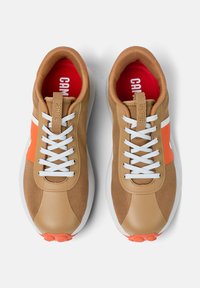 Sneakers con tomaia in tessuto beige, lacci bianchi, pannello laterale arancione acceso e suola bianca. Rivestimento interno rosso con marchio "CAMPER".