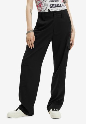 Black cargo pants with a relaxed fit, featuring side pockets and a button closure. Paired with white sneakers for contrast.