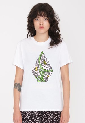 T-shirt en coton blanc avec un graphique floral coloré, avec des tiges vertes et des accents jaunes, imprimé à l'avant. Manches courtes, coupe décontractée.