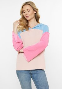 Kapuze mit horizontalen Streifen in Pink und Blau. Lange, ausgestellte Ärmel mit Rippstruktur. Weicher Stoff sorgt für eine lockere Passform.