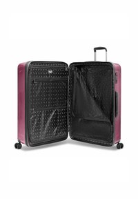 Lila Hartschalenkoffer mit vier Rädern, ausziehbarem Griff und offenem Innenraum, der mit einem schwarzen Musterfutter und Reißverschlussfächern ausgestattet ist.