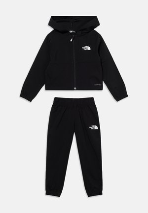 Svart treningdress for barn med hettejakke med glidelås og bukser med elastisk midje, med The North Face-logoer på bryst og lår.
