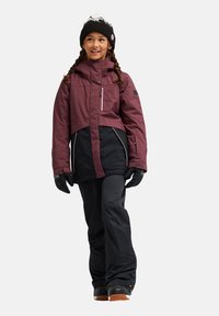 Skijack met een bordeauxrode bovenkant, zwarte onderkant en witte accenten. Beschikt over een ritssluiting aan de voorkant, knoopsluiting en geribde manchetten. Inclusief zwarte handschoenen.