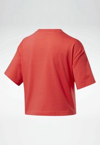 Tričko s krátkým rukávem v korálové barvě, vyrobené z měkké bavlny, s volným střihem, kulatým výst�řihem a rovný lem. Žádné viditelné vzory ani akcenty.