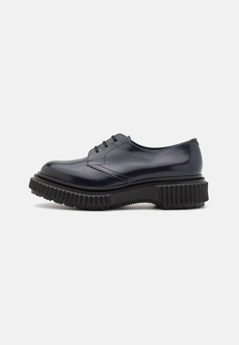 Pantofii din piele navy cu șireturi, având vârful rotund și o talpă groasă cu striații negre, prezentând un exterior neted și cusături minime.