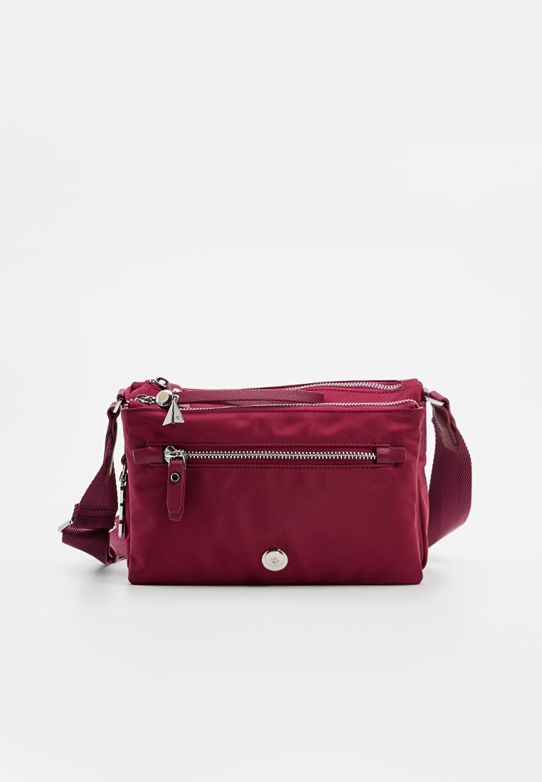 Bolso bandolera de tela burdeos con múltiples compartimentos con cremallera, correa ajustable y acentos en metal plateado. Textura suave, forma rectangular.