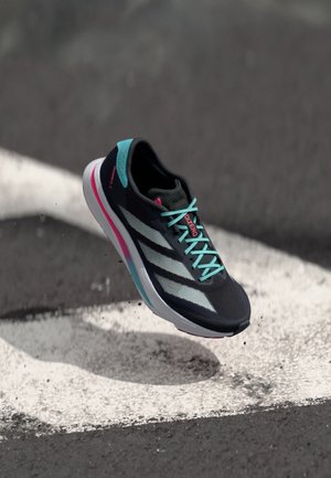 Zwarte hardloopschoen met turquoise accenten en reflecterende strepen, met een ademende mesh bovenkant en een lichte zool met roze details.