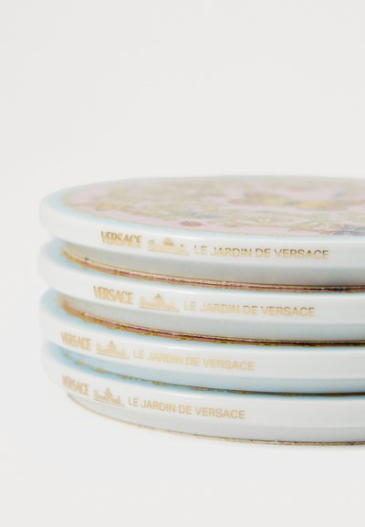 Set štirih porcelanastih krožnikov z rožnim vzorcem v pastelnih barvah, z zlatimi poudarki in napisom "VERSACE LE JARDIN DE VERSACE".