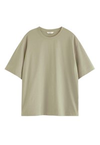 Avslappnad t-shirt med kort ärm i ljus olivgrön bomull. Har en rund halsringning och en slät, utan textur yta.