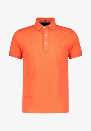 Polo orange à manches courtes avec trois boutons blancs et un petit logo sur la poitrine gauche.
