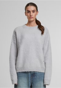 Hellgrauer Pullover aus weichem, strukturiertem Material. Verfügt über einen runden Halsausschnitt, lange Ärmel und einen gerippten Bund. Lässige Passform, minimale Details.